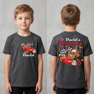 A young boy wearing a gray t-shirt with a personalized birthday design featuring a red car and the text "David's Birthday" and "David".