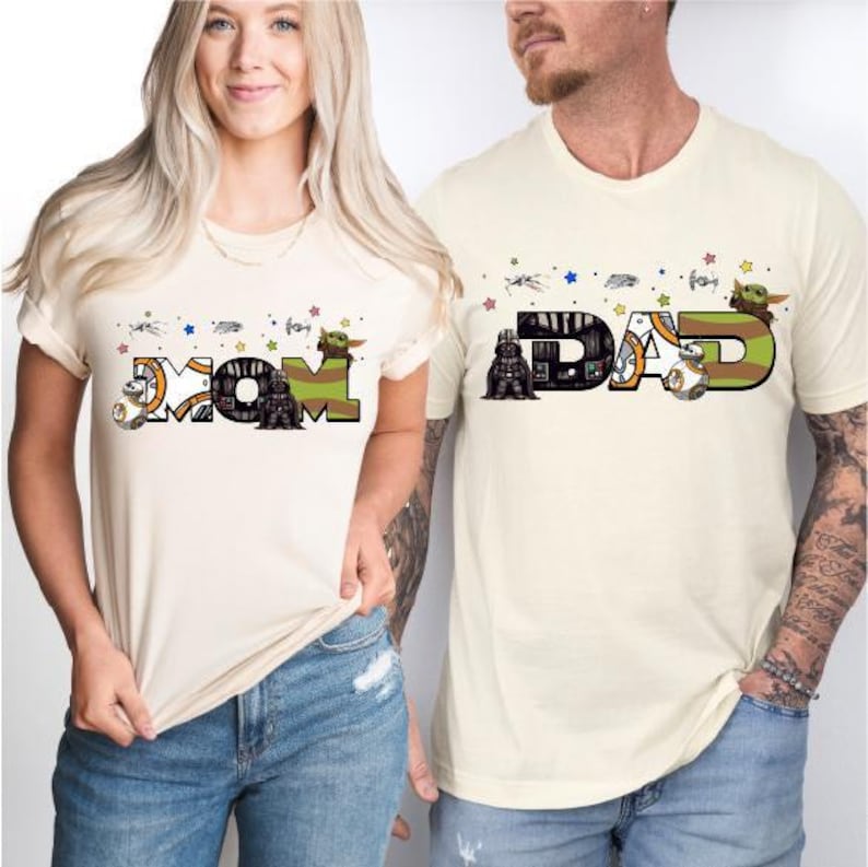 A woman and a man wearing t-shirts with the word "MOM" and "DAD" printed on them, along with various Star Wars characters and other Star Wars-themed graphics.