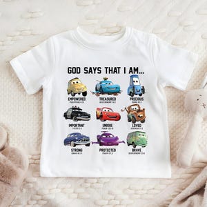 A white t-shirt with a graphic design featuring various cartoon cars and their Bible verse titles.