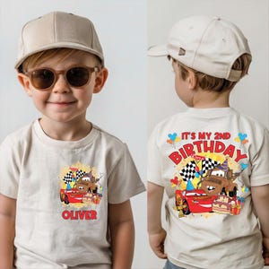 A young boy wearing a white t-shirt with a cartoon image of a car and the text "It's my 2nd birthday" printed on it.