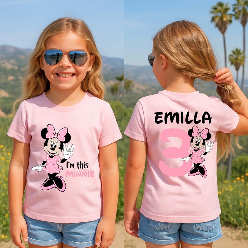 A young girl wearing a pink t-shirt with Minnie Mouse and the text "I'm this Minnie" printed on it, smiling and posing outdoors.
