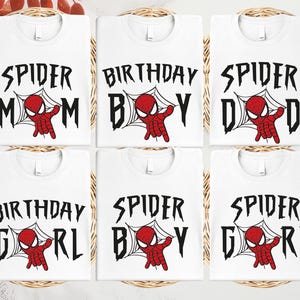 six white t-shirts with the text "SPIDER MOM" and "SPIDER BOY" printed on them, along with a Spider-Man graphic.