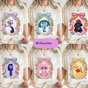 The image is a collage of six images, each featuring a different cartoon character on a white t-shirt. The characters include a character with a purple bow, a character with a blue bow, a character with a black bow, a character with a pink bow, a character with a yellow bow, and a character with a pink bow. The collage is titled "All Characters" and includes a pink banner at the bottom.