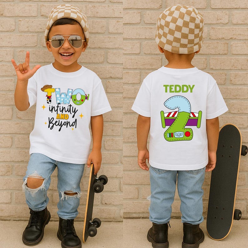 A young boy wearing a white t-shirt with a cartoon character and text, holding a skateboard, and smiling.