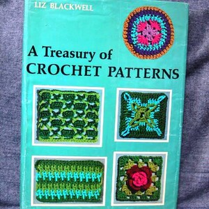 Peut inclure: Un livre turquoise intitulé "A Treasury of Crochet Patterns" par Liz Blackwell. La couverture présente un motif de crochet coloré et quatre exemples de motifs de crochet plus petits. Le livre est un guide pour les amateurs de crochet.