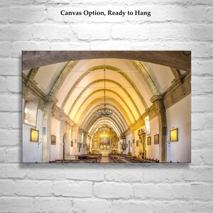 May include: A photograph of the interior of a church with a high vaulted ceiling and rows of pews. The altar is at the far end of the church, and there are stained glass windows on either side.