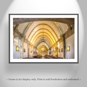 May include: A wide shot of the interior of a church with a high vaulted ceiling and rows of pews. The ceiling is made of wood and has a light brown color. The walls are white and the pews are made of dark wood. There is a large chandelier hanging from the ceiling.