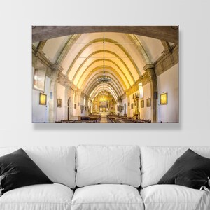 May include: A wide shot of the interior of a church with a vaulted ceiling and rows of pews. The ceiling is made of wood and has a light brown color. The pews are made of wood and have a dark brown color. The church is lit by a large chandelier hanging from the ceiling.