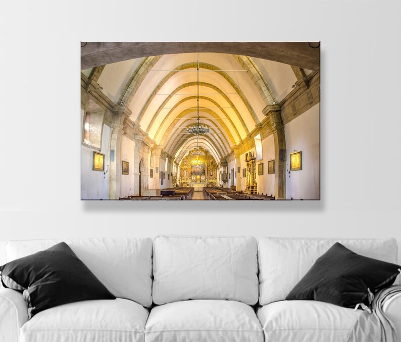May include: A wide shot of the interior of a church with a vaulted ceiling and rows of pews. The ceiling is made of wood and has a light brown color. The pews are made of wood and have a dark brown color. The church is lit by a large chandelier hanging from the ceiling.
