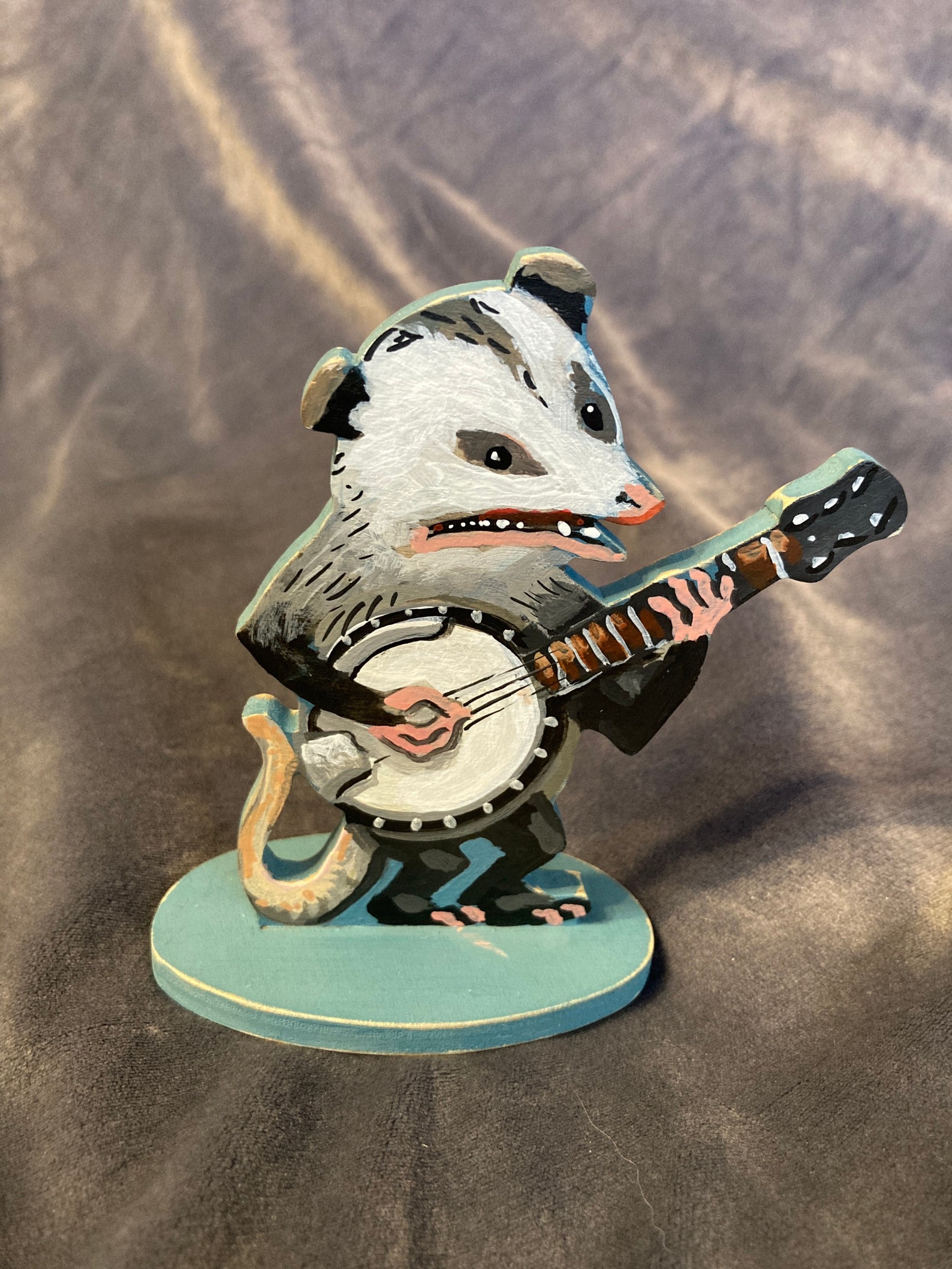 wooden figure of a possum playing a banjo.