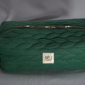 May include: A green quilted travel bag with a zipper closure and a small label that reads "BEJ store".
