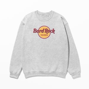 May include: A gray sweatshirt with a yellow circle and the text "Hard Rock Tavern" in red.