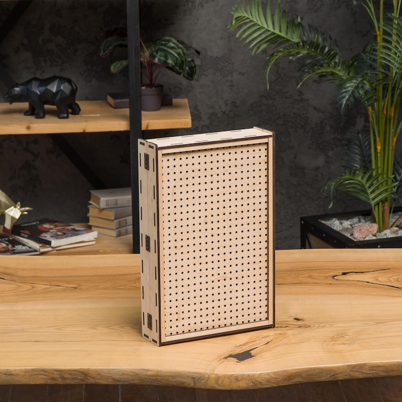 May include: A wooden pegboard with a brown frame. The pegboard has a grid of evenly spaced holes.