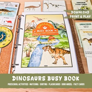 May include: A colourful dinosaur busy book with a green, blue and brown cover. The cover features a T-Rex dinosaur, a river and mountains. The title of the book is "Dinosaurs Busy Book". The book includes preschool activities, matching, sorting, flashcards, a dino wheel and fact cards.