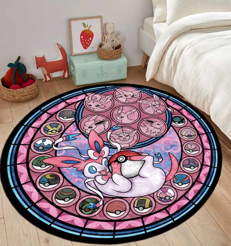 May include: A circular area rug featuring a stained-glass style design with a central Sylveon character holding a Pok&eacute; Ball. The border contains circular frames displaying various Eeveelutions and Pok&eacute; Balls in shades of pink, blue, and black.