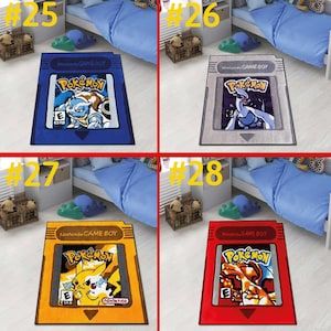 May include: A collection of four rectangular area rugs designed to look like Nintendo Game Boy game cartridges. Each rug features a Pok&eacute;mon character illustration, the Pok&eacute;mon logo, and the ESRB rating symbol on a blue, gray, yellow, or red background.