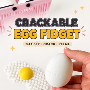 May include: A white egg-shaped fidget toy with a yellow yolk centre, accompanied by a pink plastic basket containing additional white eggs. The image features the text CRACKABLE EGG FIDGET and SATISFY CRACK RELAX with yellow star accents.
