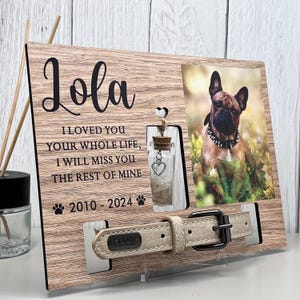May include: A wooden pet memorial frame with a photo of a dog, a small glass bottle, and a dog collar. The frame includes the name "Lola", the years 2010-2024, and the text "I LOVED YOU YOUR WHOLE LIFE, I WILL MISS YOU THE REST OF MINE."