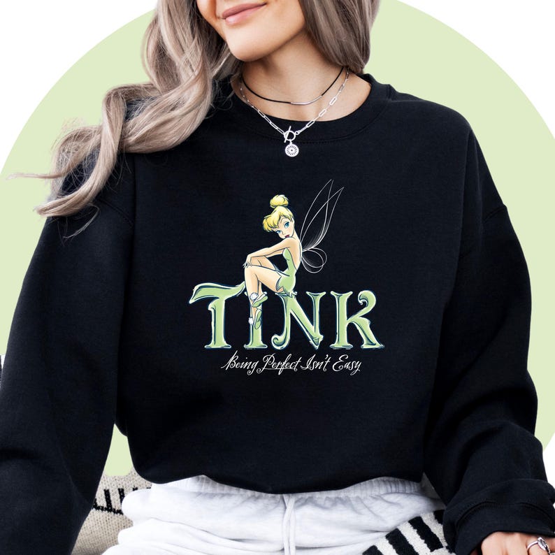 May include: Black sweatshirt with a green graphic of Tinkerbell sitting on the word "TINK" with the text "being perfect isn't easy" below.