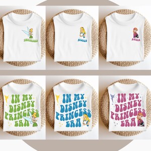 May include: Six white t-shirts with different Disney princess designs. The shirts feature Tinkerbell, Alice, and Anna. The text on the shirts says "In My Disney Princess Era".