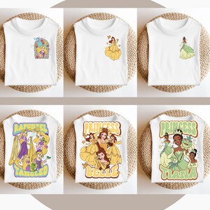 May include: Six white t-shirts featuring different Disney princess designs. The shirts depict Rapunzel, Belle, and Tiana. The designs are in a retro style with colourful graphics and text.