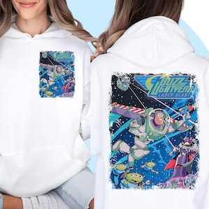 May include: White hoodie with a graphic print of Buzz Lightyear from Toy Story. The graphic shows Buzz in space with his spaceship and other characters. The text "Buzz Lightyear Laser Blast" is printed on the graphic.