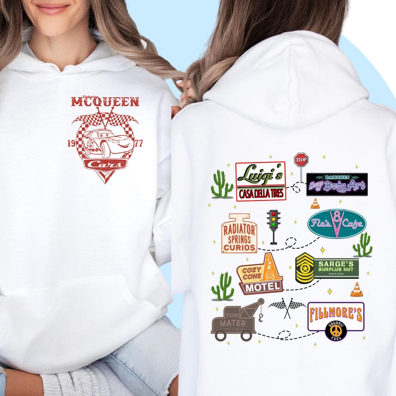 May include: White hoodie with a red graphic of Lightning McQueen from the movie Cars. The back of the hoodie features a map of Radiator Springs with various landmarks and businesses from the movie.