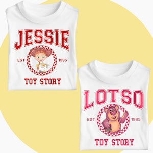 May include: Two white t-shirts with Toy Story designs. One displays "Jessie" in red, above a cartoon image of the character. The other features "Lotso" in pink, with a cartoon image of the character. Both shirts have "Toy Story" printed.
