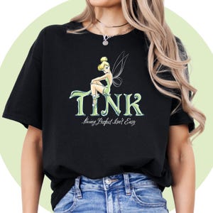 May include: Black t-shirt with a green Tinkerbell graphic and the text "TINK? Being Perfect Isn't Easy".