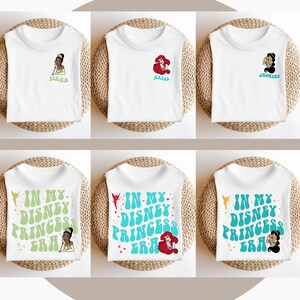 May include: Six white t-shirts with different Disney princess designs. The shirts feature the princesses Tiana, Ariel, Jasmine, and the text "In My Disney Princess Era".