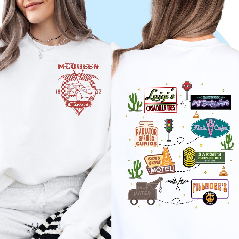 May include: White sweatshirt with a red graphic of Lightning McQueen from the Cars movie. The back of the sweatshirt has a white graphic of a road trip route with various landmarks from the movie, including Luigi's Casa Della Tires, Radiator Springs Curios, Cozy Cone Motel, and Fillmore's.