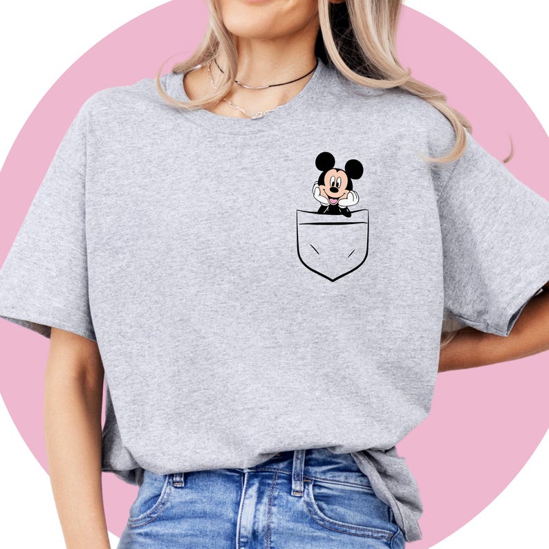 May include: A gray t-shirt with a pocket featuring a cartoon image of Mickey Mouse.