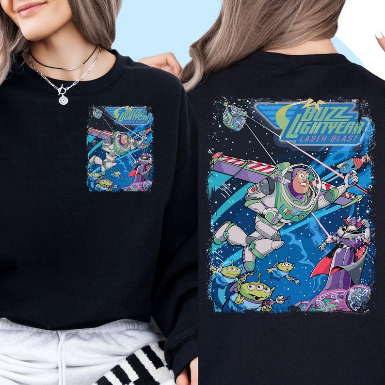 May include: Black sweatshirt with a graphic print of Buzz Lightyear from the Toy Story franchise. The graphic features Buzz Lightyear flying in space with a laser blast. The text "Buzz Lightyear Laser Blast" is printed on the graphic.