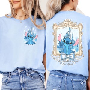 Puede incluir: Dos camisetas de color azul claro con un personaje azul Stitch. La camiseta delantera presenta a Stitch frente a un castillo. La camiseta trasera presenta a Stitch en un marco con un castillo y el texto "The Happiest Place On Earth".