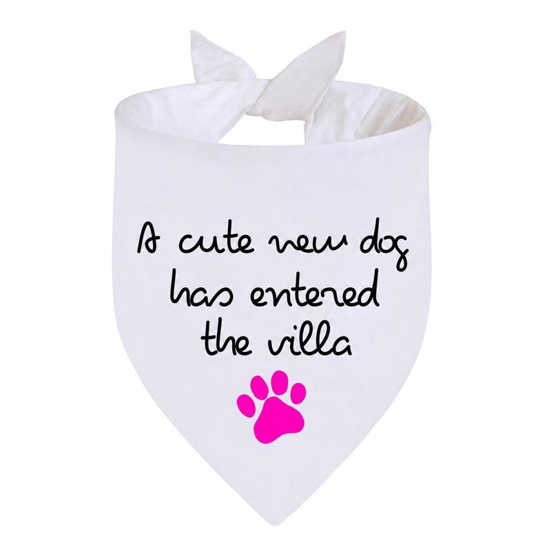 May include: A white triangular pet bandana featuring the black text "A cute new dog has entered the villa" and a bright pink paw print graphic. The fabric is tied at the top with two ends, creating a pointed shape at the bottom for a pet to wear.