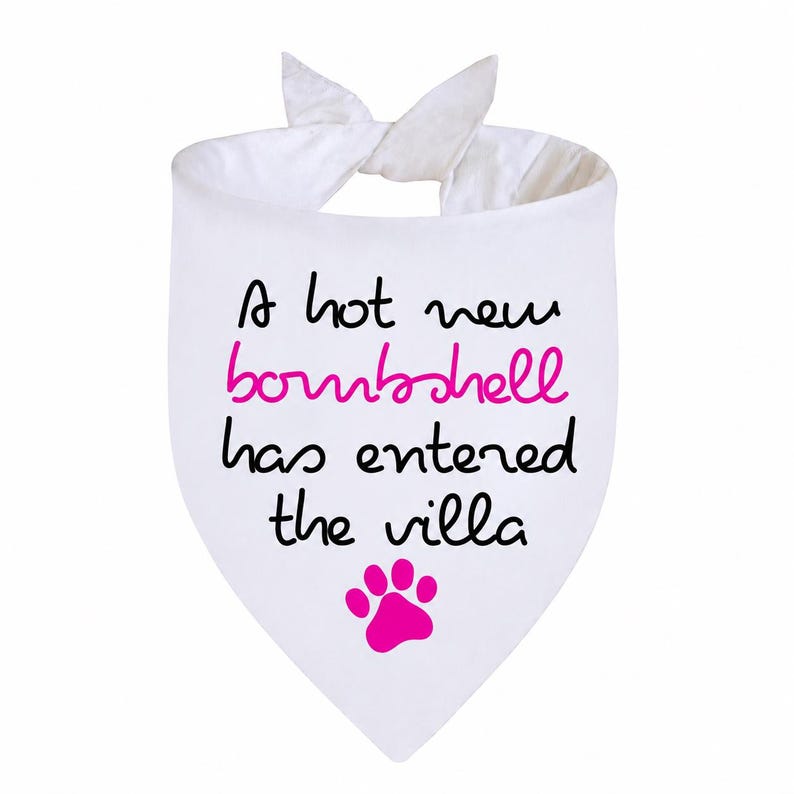 May include: A white triangular pet bandana featuring the black text A hot new, the pink text bombshell, and the black text has entered the villa. Below the text is a single pink paw print. The bandana has two fabric ties at the top.