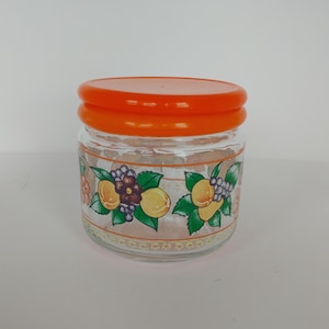 Orangefarbene Deckeldose aus Glas mit Obst /Obst-Motiv