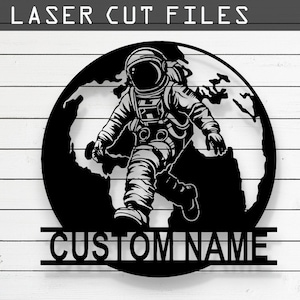 May include: Black and white laser cut file design of an astronaut walking on a globe with the text "CUSTOM NAME" below. The design is available in CDR, AI, SVG, DXF, and PDF formats.