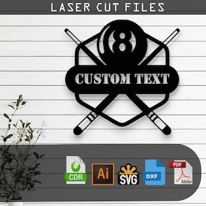 Puede incluir: Diseño de archivo de corte por láser en blanco y negro de un taco de billar cruzado sobre una bola de billar con el número 8. El diseño tiene una pancarta que dice "CUSTOM TEXT". El diseño está disponible en los formatos CDR, AI, SVG, DXF y PDF.