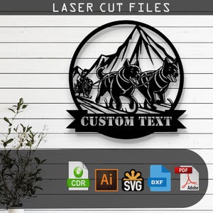 May include: Black metal wall art featuring a dog sled team with two dogs pulling a sled across a snowy mountain landscape. The words "LASER CUT FILES" are at the top, and "CUSTOM TEXT" is at the bottom. Includes file type icons.