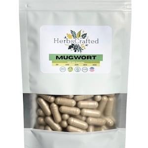 以下が含まれることがあります： ベージュ色のカプセルが多数入った、透明な窓付きの白いパウチ。パウチには「HerbsCrafted」と「MUGWORT」の文字が入ったラベルが付いています。ラベルにはカプセルの数も記載されています。