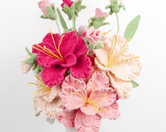 Puede incluir: Un ramo de flores de ganchillo hechas a mano en un jarrón blanco. Las flores son en tonos de rosa, melocotón y verde, con estambres amarillos. El ramo incluye lirios, rosas y capullos. El texto "Knot That Bloom" es visible.