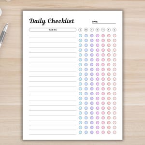 Puede incluir: Una lista de verificación diaria imprimible con un espacio en blanco para la fecha y una sección para tareas. La lista de verificación tiene una cuadrícula de círculos en un degradado de colores azul, morado y rosa que representan cada día de la semana.