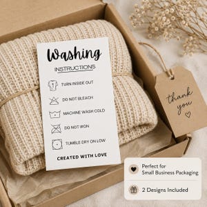 May include: A beige ribbed knit garment inside a cardboard box with a white washing instructions card. The card lists: Turn inside out, Do not bleach, Machine wash cold, Do not iron, Tumble dry on low, and Created with love. A brown tag says thank you.