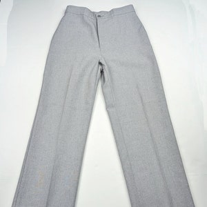Puede incluir: Un pantalón gris de pierna recta con cierre de botón.