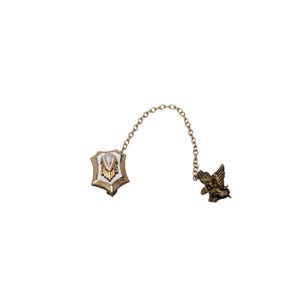 May include: A gold chain with a white enamel and gold shield charm with a diamond-shaped stone and a gold eagle charm.