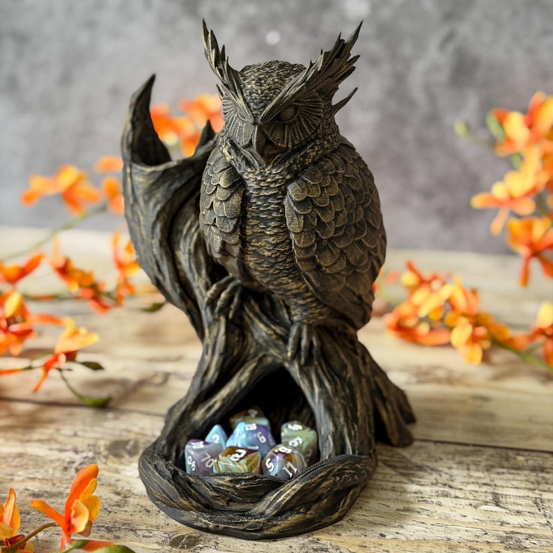 3D-geprinte uil op een tak. De Owl Dice Tower is geverfd met Rub 'n Buff, waardoor het van brons lijkt.