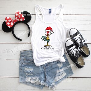 May include: White vest top featuring a cartoon rooster in a Santa hat with the words "MERRY CHRISTMAS". The image also shows denim shorts, black trainers, and a black headband with red polka dot ears.