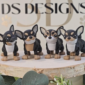 May include: Four 3D-printed Chihuahua figurines. Each dog has a black coat with tan and white markings. The figurines are displayed on a wooden slice, with the text "3D DESIGNS" in the background.