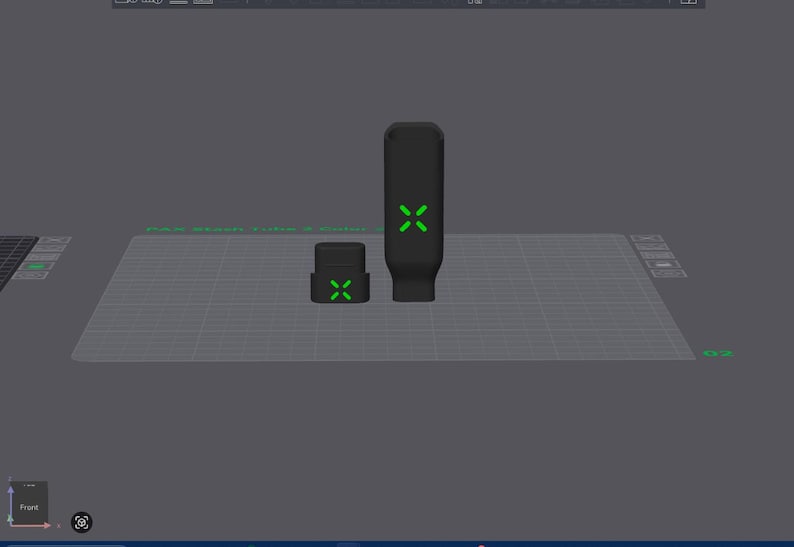 May include: Two black, rectangular objects with green cross-shaped designs. One is tall and cylindrical, the other is shorter and square. The objects are on a grey surface.